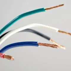 Kolorowe przewody elektryczne, każdy z odsłoniętym miedzianym rdzeniem. Widoczne oznaczenie prądu L na niebieskim przewodzie.
